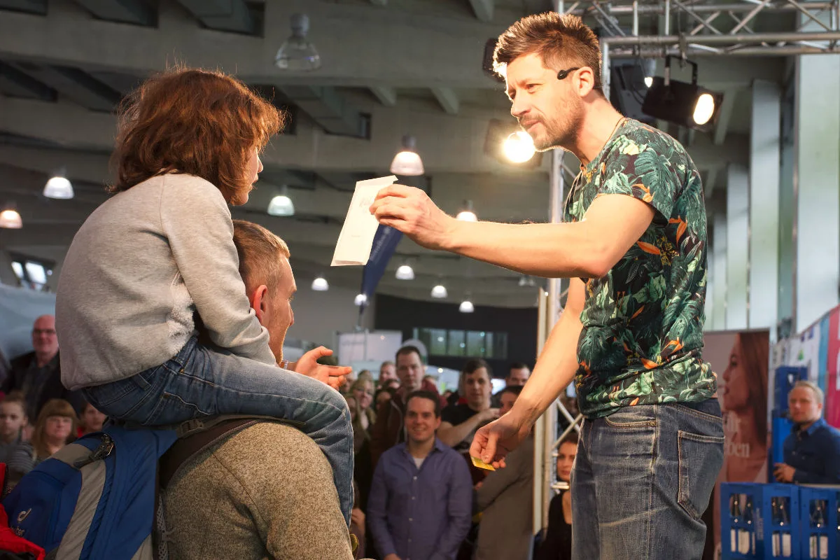Eventfotografie: Moderator auf der Bühne vor Publikum