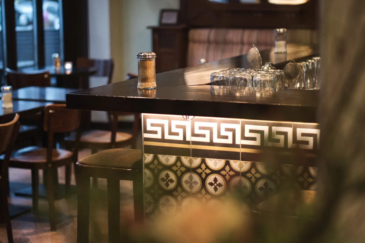 Locationfotografie: Tresen einer Bar mit gemusterten Fliesen und Gläsern